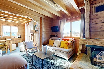 A living room with a couch and a table and a sign that says alpine property