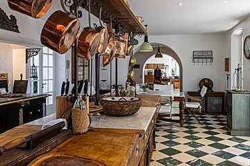 A kitchen with copper pots and pans and a sign that says attention