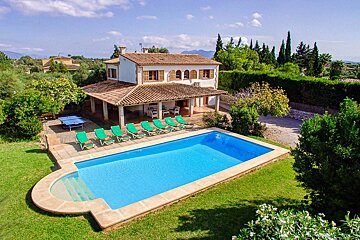 A large house with a large swimming pool in front of it