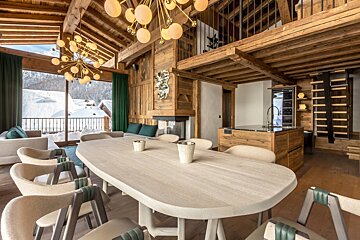 Luxurious alpine chalet dining room with wooden interiors, modern globe chandeliers, and scenic snowy mountain views.