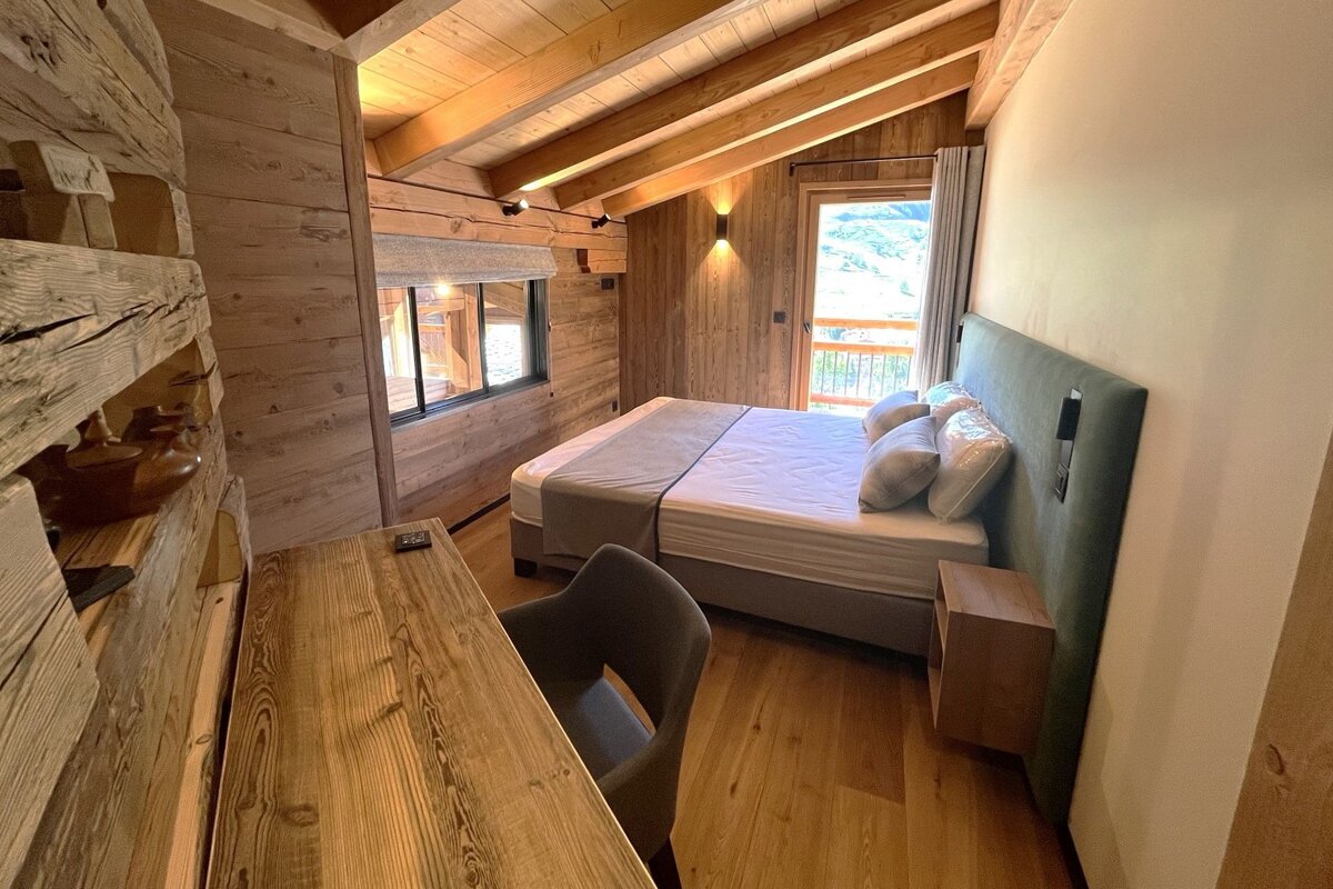 A bedroom with a large bed and a desk