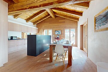 A dining room with a long table and chairs