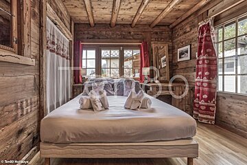 A bed in a wooden cabin with a towel that says t80 on it