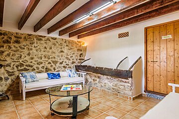 A room with a couch and a table with a sign on the door that says ' alquiler '