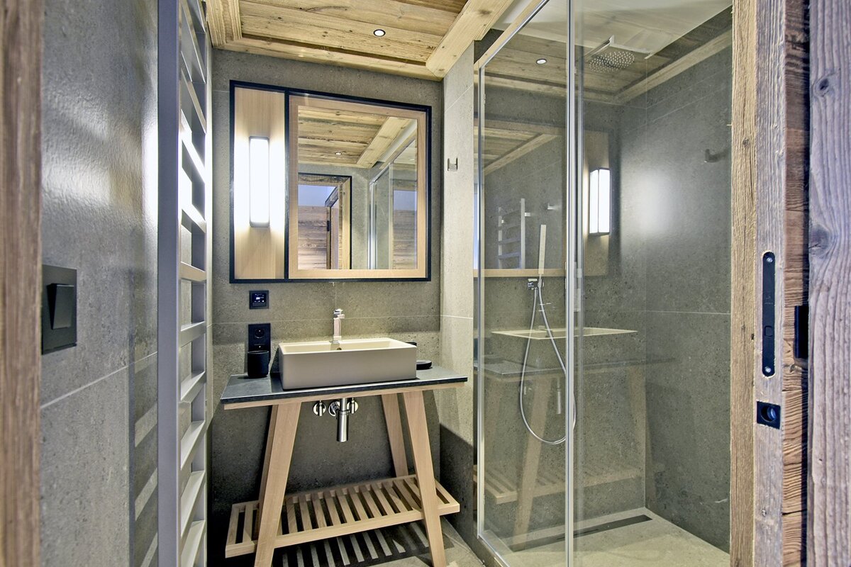 A bathroom with a sink a mirror and a walk in shower