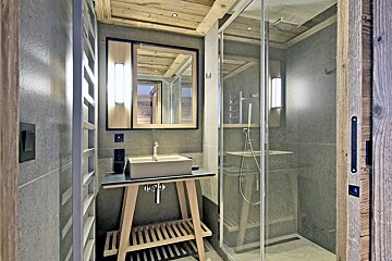 A bathroom with a sink a mirror and a walk in shower