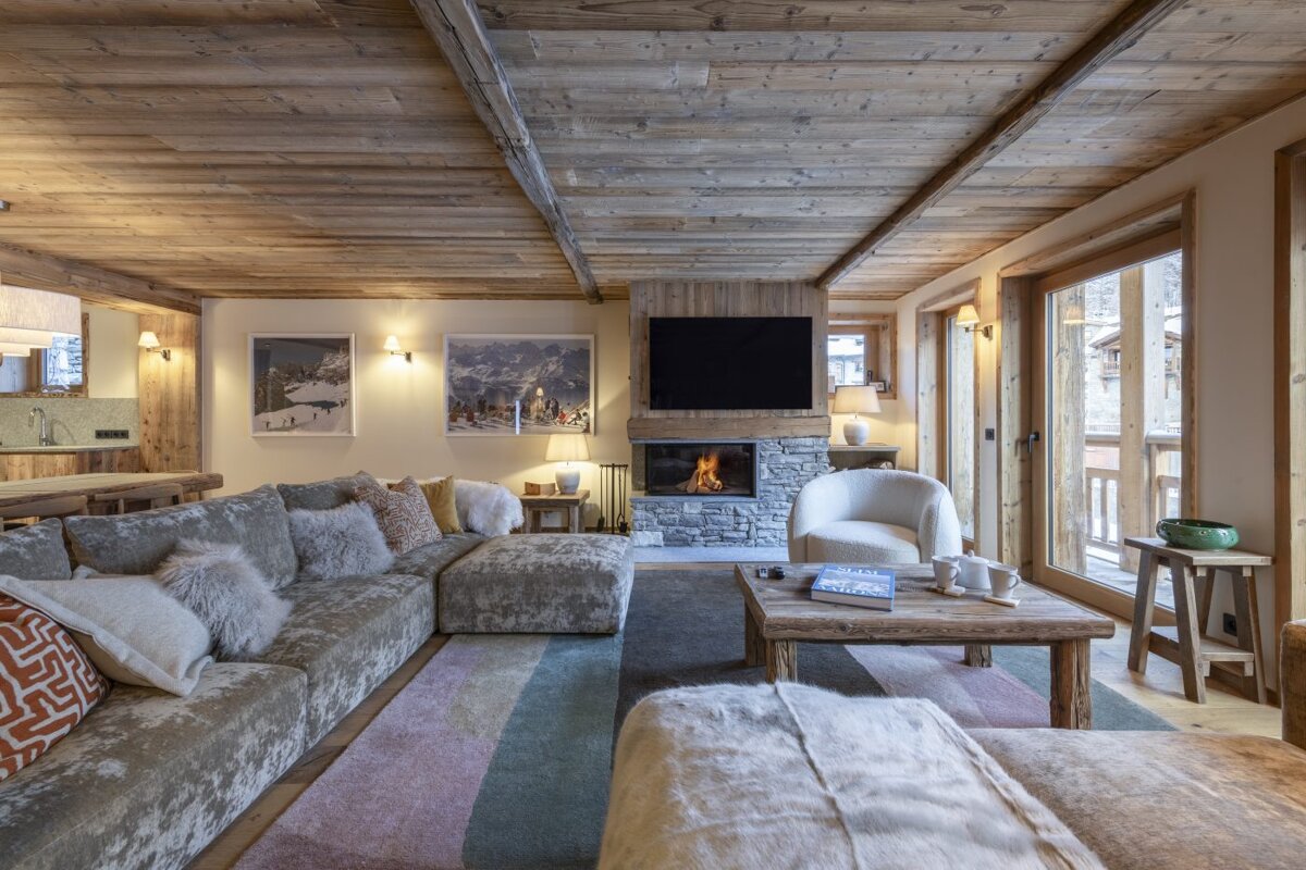 A living room with a stone fireplace and a flat screen tv