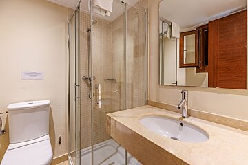 A bathroom with a toilet a sink and a shower