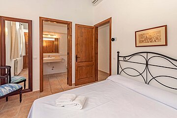 A bedroom with a bed and a picture on the wall
