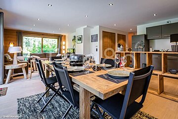 A wooden dining table with black chairs in a living room