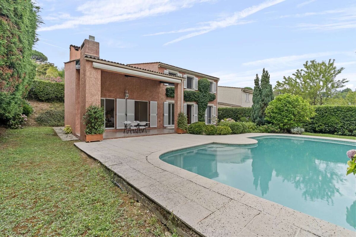 A house with a large swimming pool in front of it