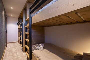 A row of bunk beds are lined up in a hallway