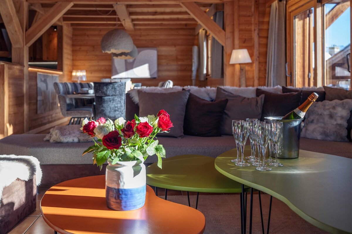 A vase of red roses sits on a table in a living room