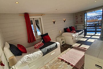A bedroom with two beds and a dresser
