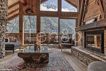 A living room with a fireplace and mountains in the background