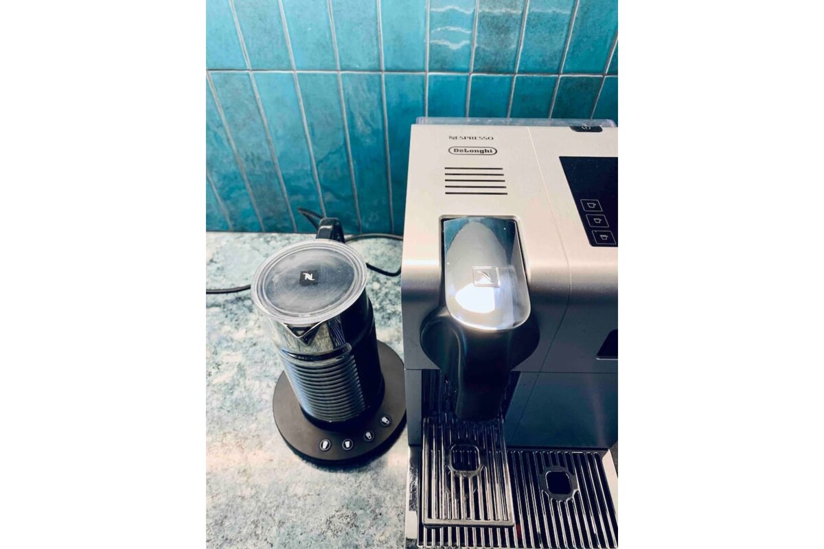A delonghi nespresso machine sits on a counter