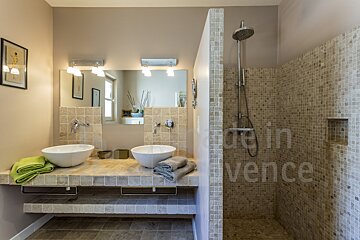 A bathroom with two sinks and a walk in shower made in provence