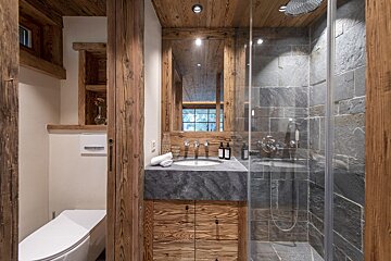 A bathroom with a walk in shower and a sink
