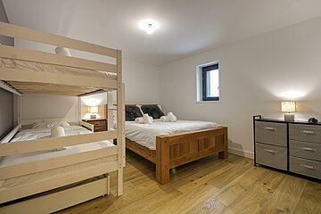 A bedroom with a bunk bed and two beds