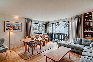 A living room with a couch a table and chairs