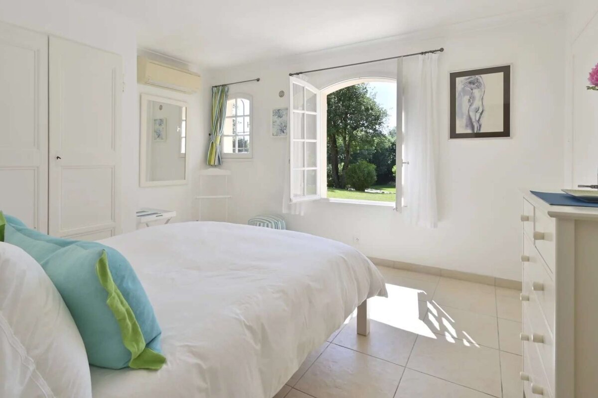 A bedroom with a large bed and a window