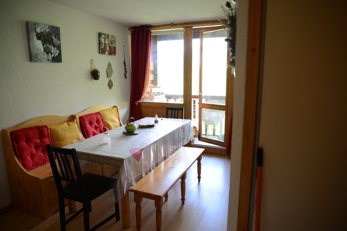 A dining room with a table and chairs and a bench