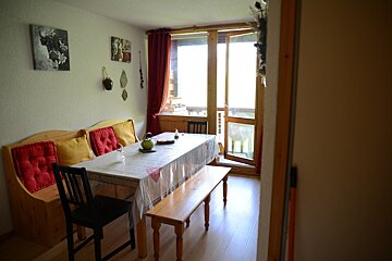 A dining room with a table and chairs and a bench