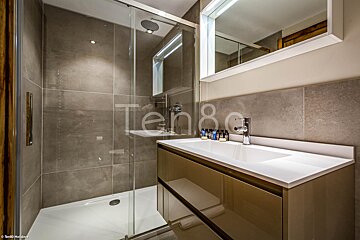 A bathroom with a sliding glass shower door and a sink