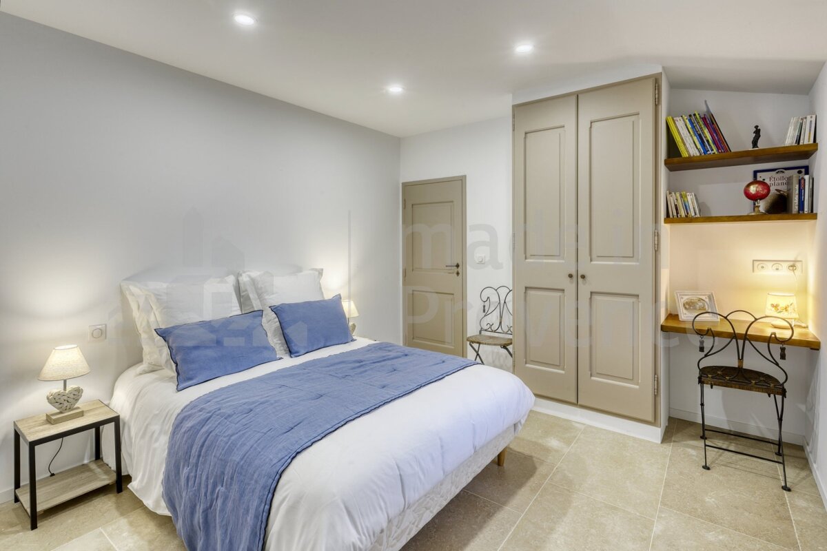 A bedroom with a white bed and blue pillows