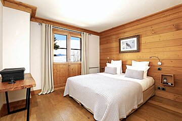 A bedroom with a bed and a picture on the wall