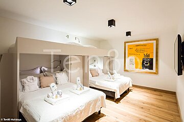 A bedroom with a bunk bed and a painting on the wall