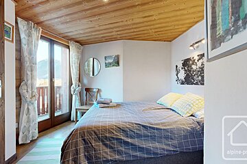 A bedroom with a large bed and a sign that says alpine-pro