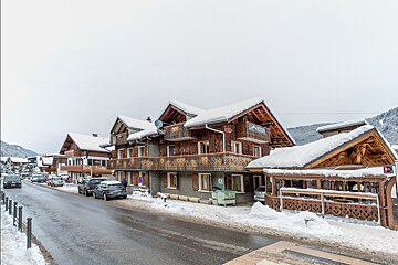 A row of snow covered buildings with a sign that says ' altitude ' on it