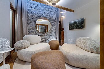 A room with two chairs and a tv on the wall