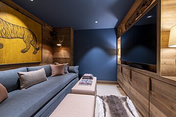A couch in a room with a painting of a tiger on the wall