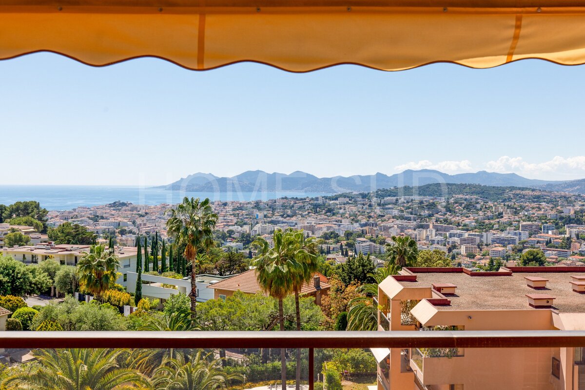 A balcony with a view of a city and the ocean