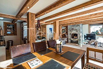 A dining room table with a bottle of wine on it