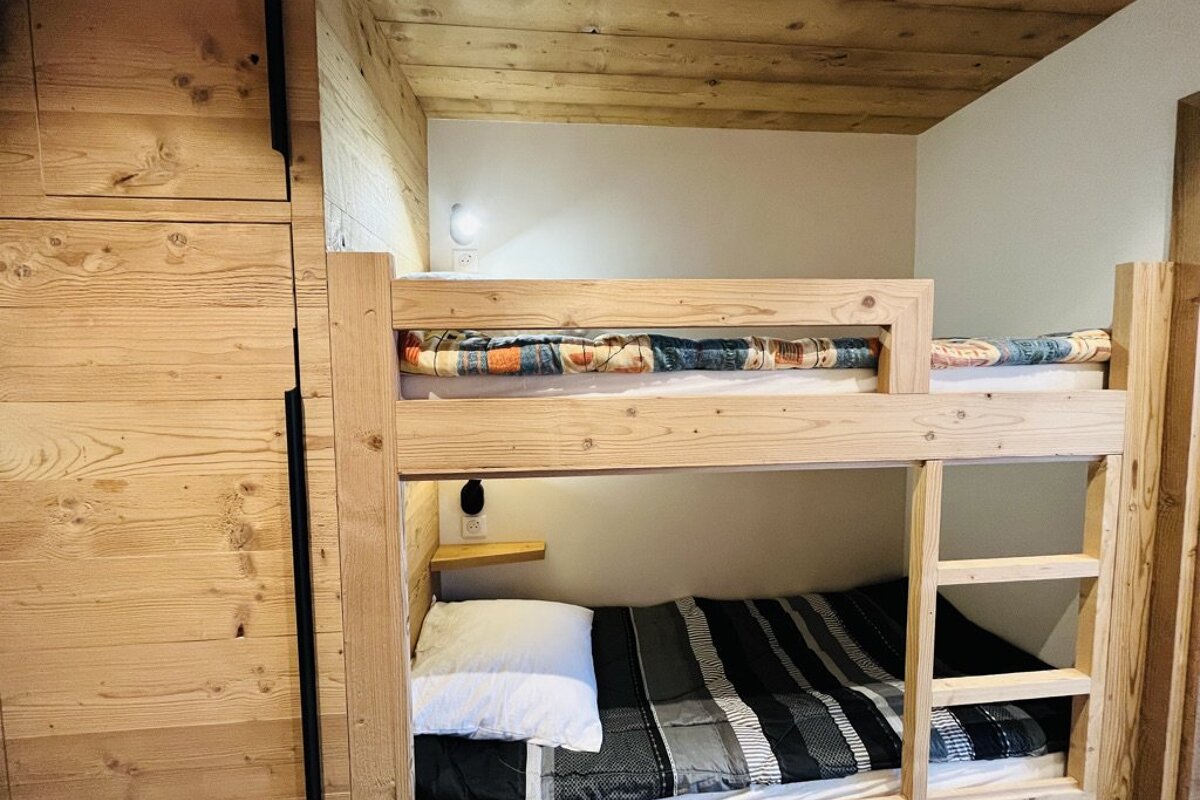 A bunk bed with a black and white striped comforter