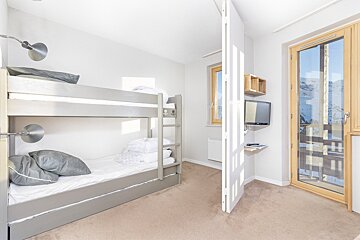 A bedroom with bunk beds and a television