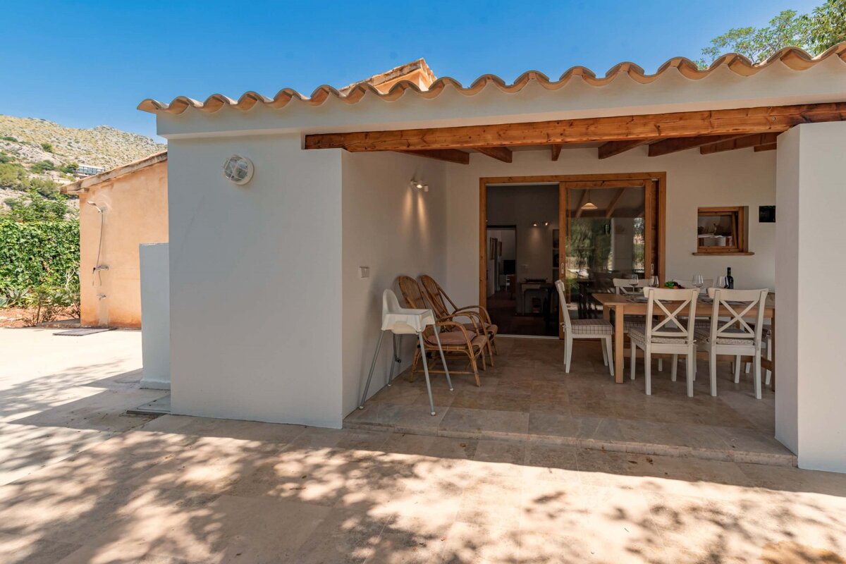 A patio with a table and chairs and a high chair