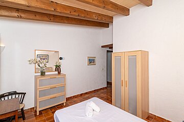 A bedroom with a bed dresser and a mirror