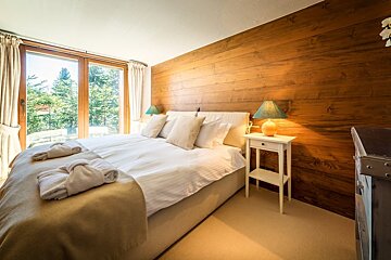 A bedroom with a large bed and two lamps
