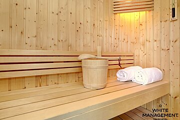 A wooden sauna with two towels and a wooden bucket