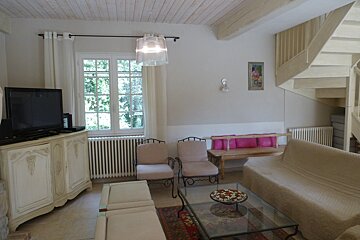 A living room with a couch and chairs and a flat screen tv