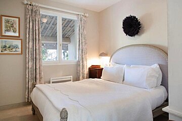 A bedroom with a bed and two pictures on the wall