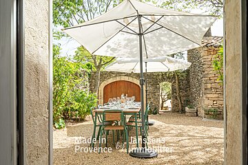 A table and chairs under an umbrella made in provence