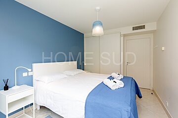 A bedroom with blue walls and the word home sud on the wall