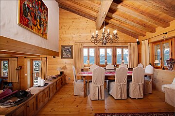 A dining room with a table and chairs and a chandelier