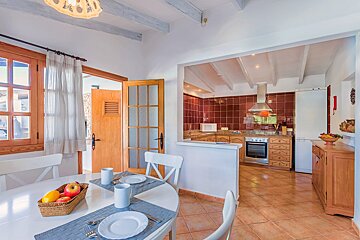 A kitchen and dining area with plates and utensils on the table