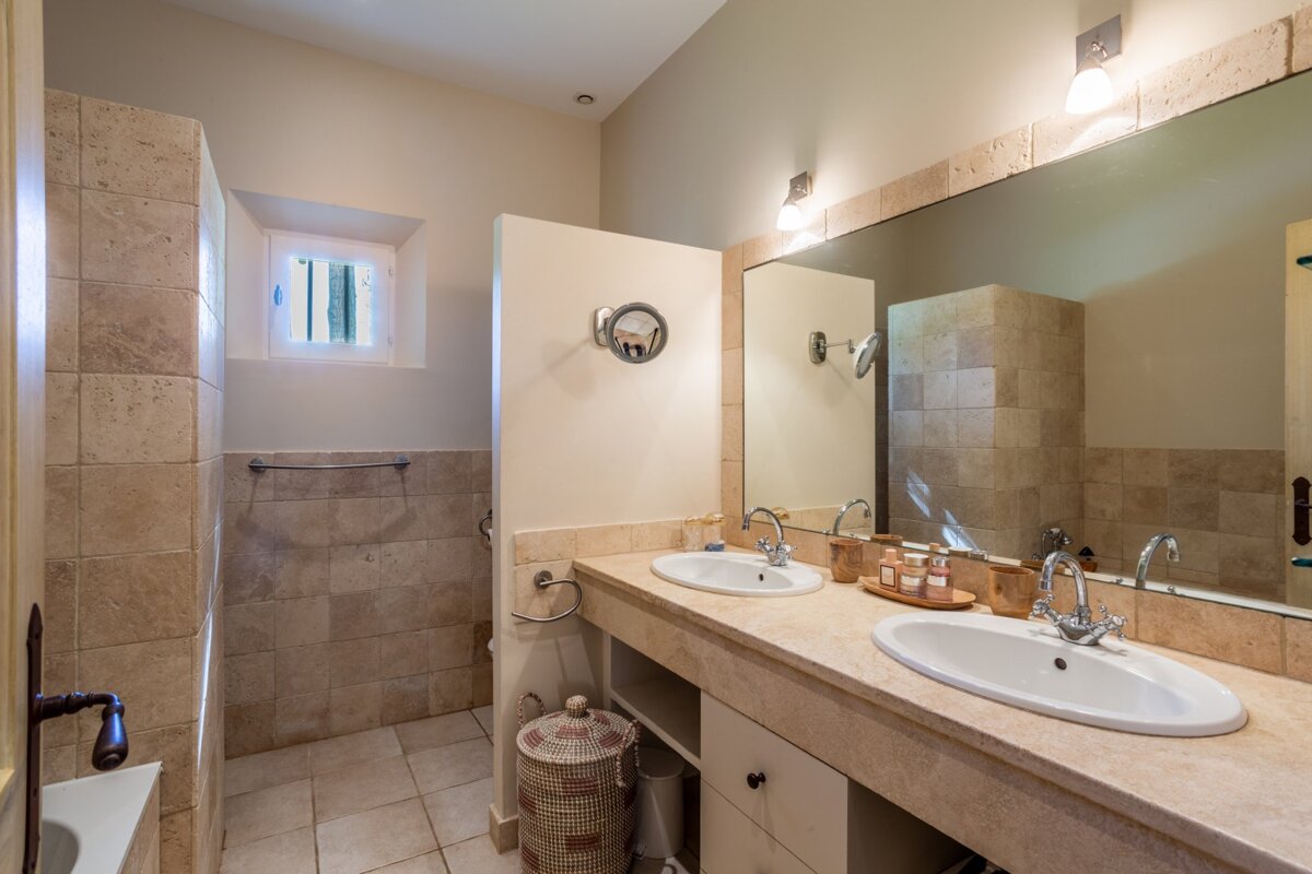 A bathroom with two sinks and a large mirror
